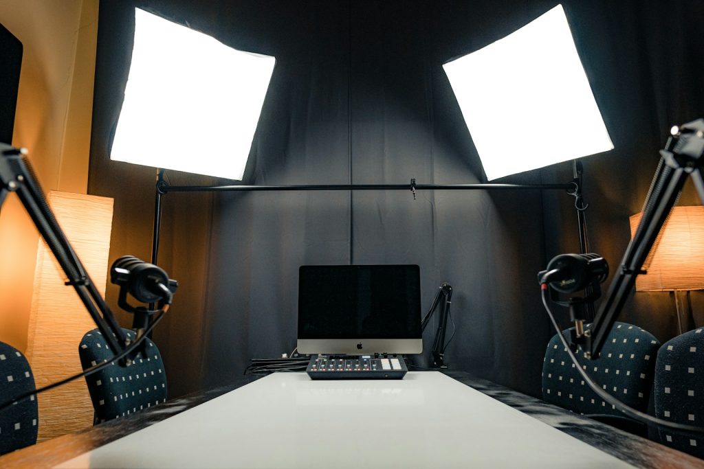 a desk with a laptop and microphones